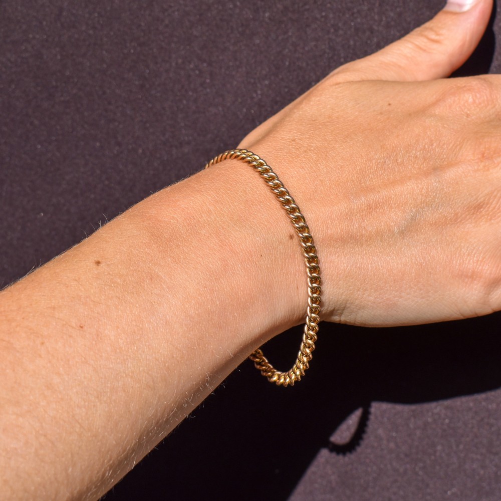 An antique 9ct yellow gold curb link chain bracelet fitted with a dog clip swivel clasp. View X