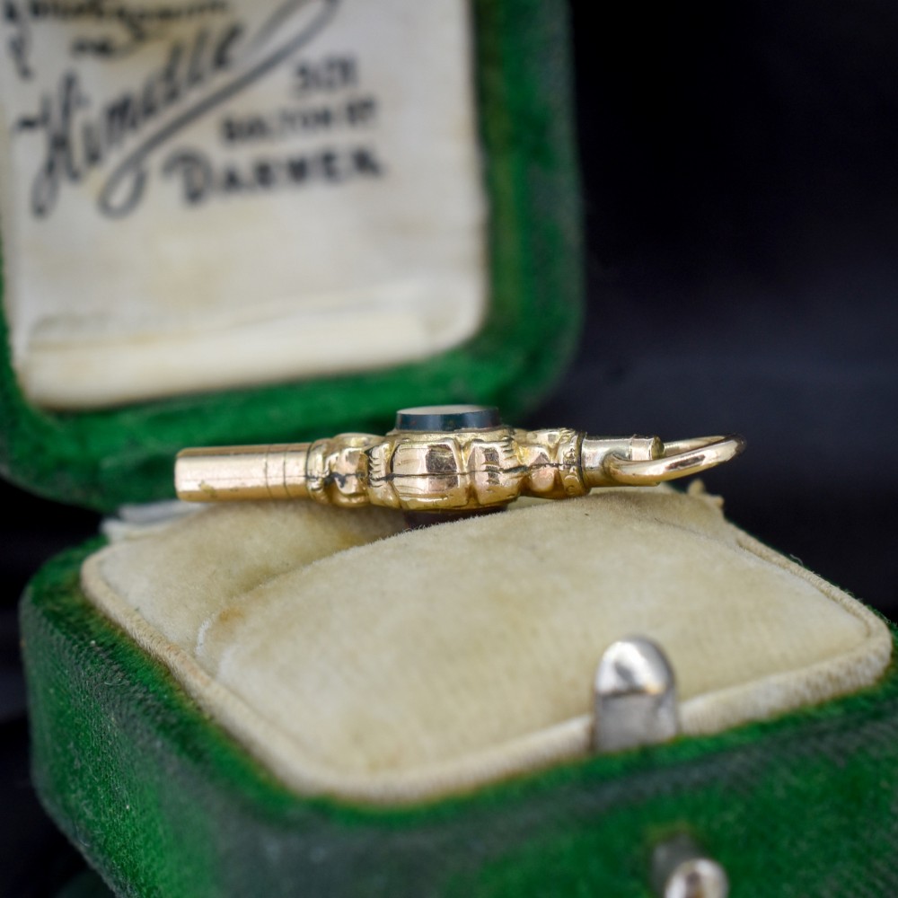 A gold-cased pocket watch key set with a central round dark green agate stone and fitted with a top suspension ring. View III