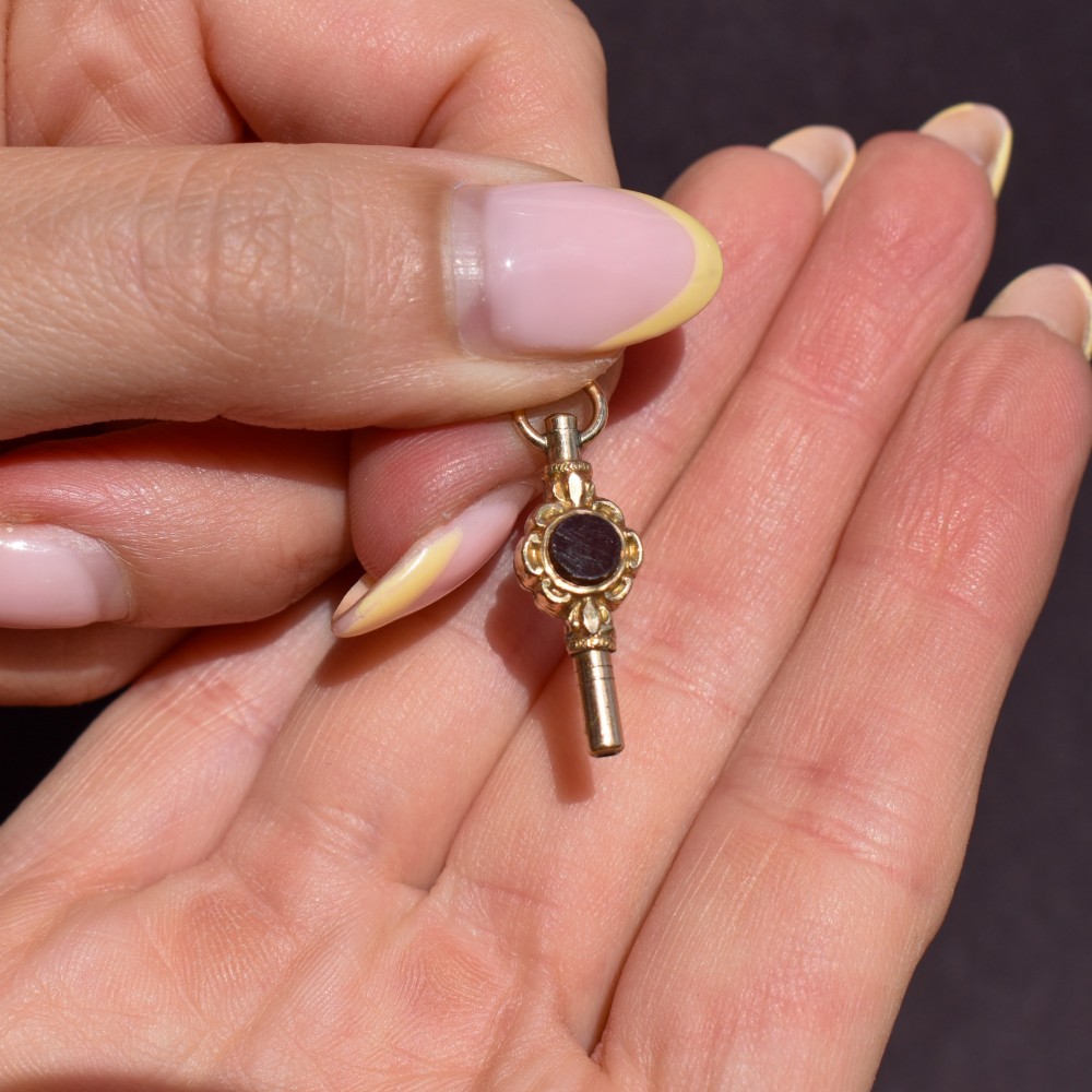 A gold-cased pocket watch key set with a central round dark green agate stone and fitted with a top suspension ring. View VII