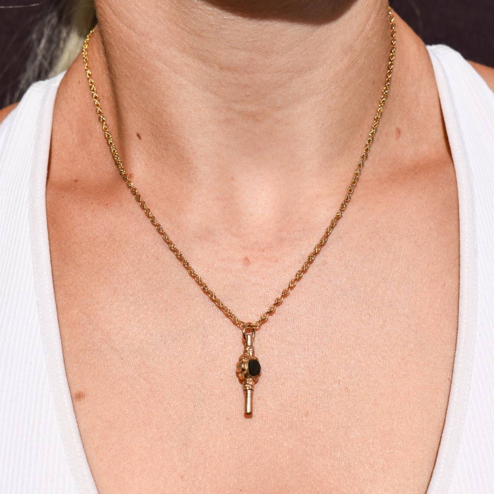 A gold-cased pocket watch key set with a central round dark green agate stone and fitted with a top suspension ring. View VIII