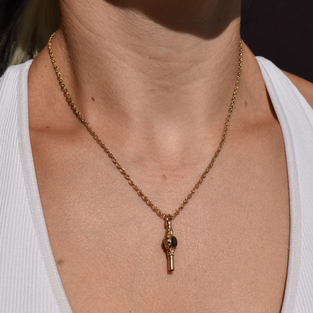 A gold-cased pocket watch key set with a central round dark green agate stone and fitted with a top suspension ring. View IX