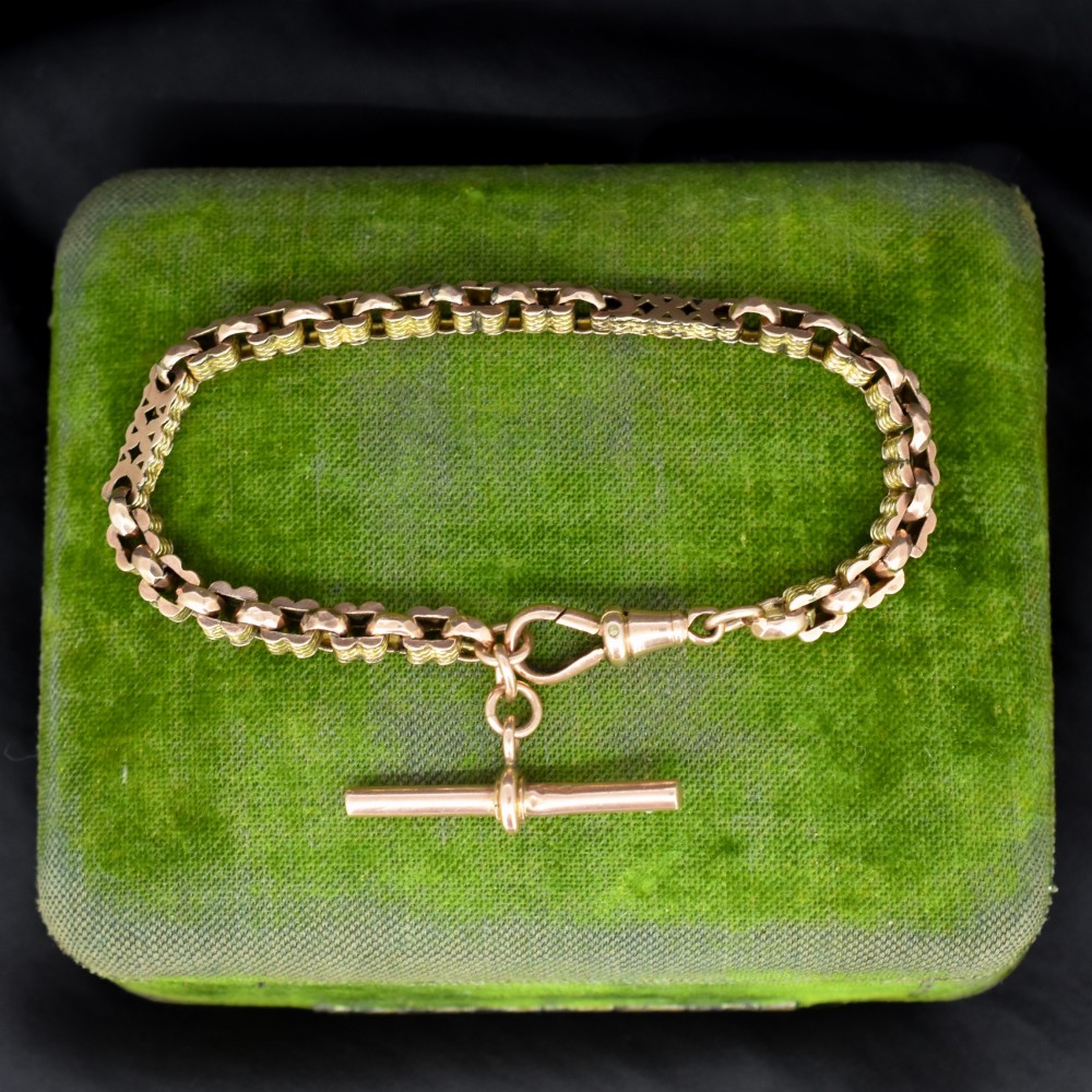 An antique 9ct yellow gold fancy link chain bracelet with a swivel clasp and suspended T-bar element.