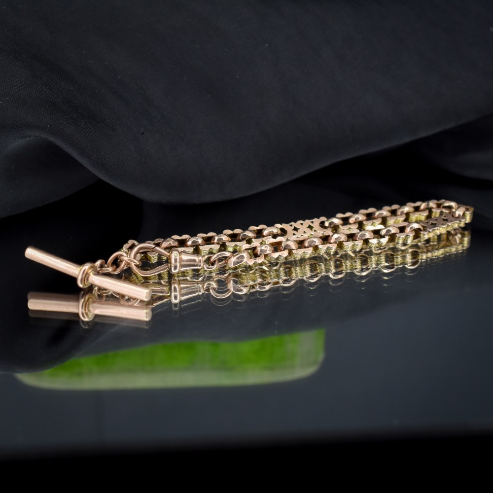 An antique 9ct yellow gold fancy link chain bracelet with a swivel clasp and suspended T-bar element. View II