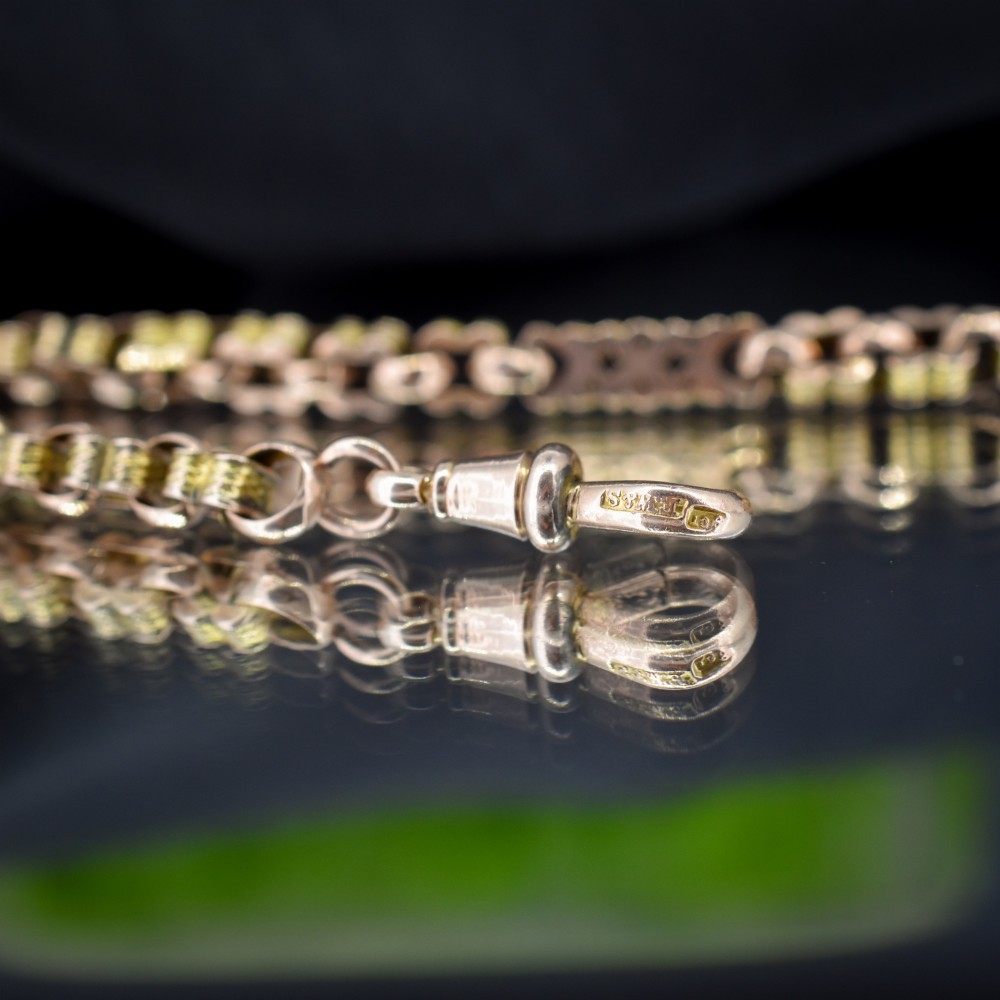 An antique 9ct yellow gold fancy link chain bracelet with a swivel clasp and suspended T-bar element. View IV