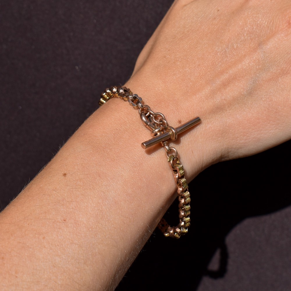 An antique 9ct yellow gold fancy link chain bracelet with a swivel clasp and suspended T-bar element. View VIII