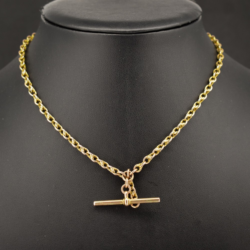 An antique 9ct gold double Albert watch chain featuring love knot links, two swivel clasps, and a central T-bar. View II