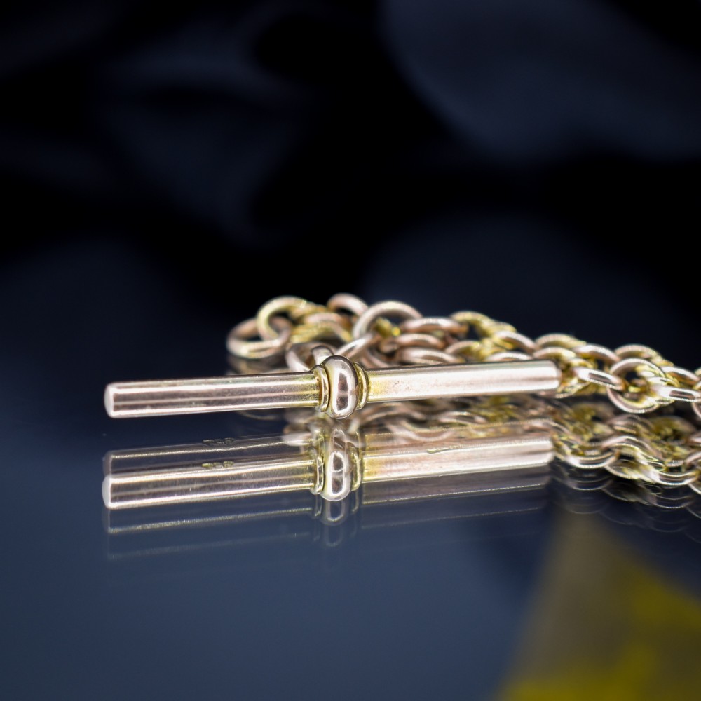 An antique 9ct gold double Albert watch chain featuring love knot links, two swivel clasps, and a central T-bar. View VII