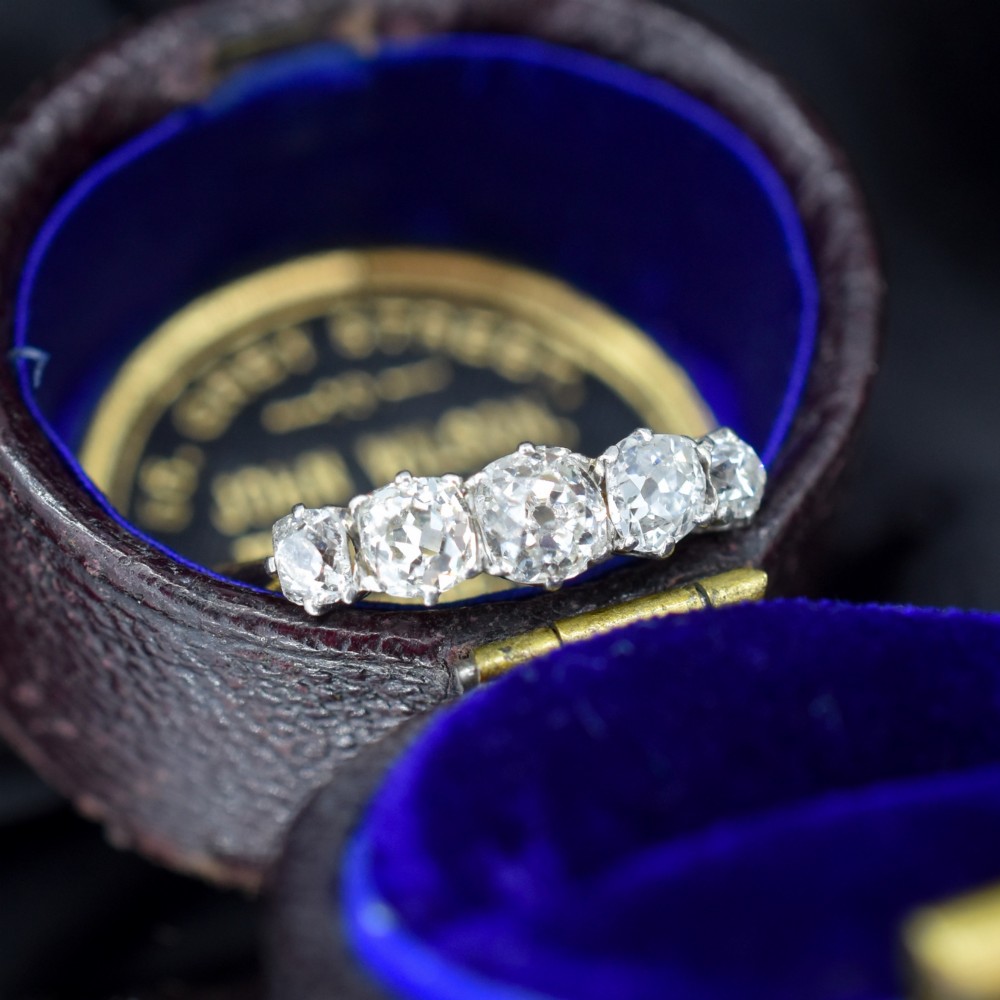 An antique five-stone ring featuring five graduated old cut diamonds set in a row mounted on a gold band. View III