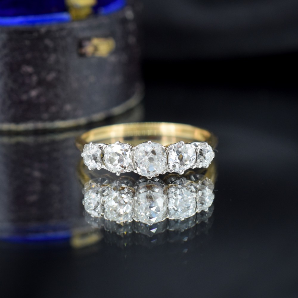 An antique five-stone ring featuring five graduated old cut diamonds set in a row mounted on a gold band. View V