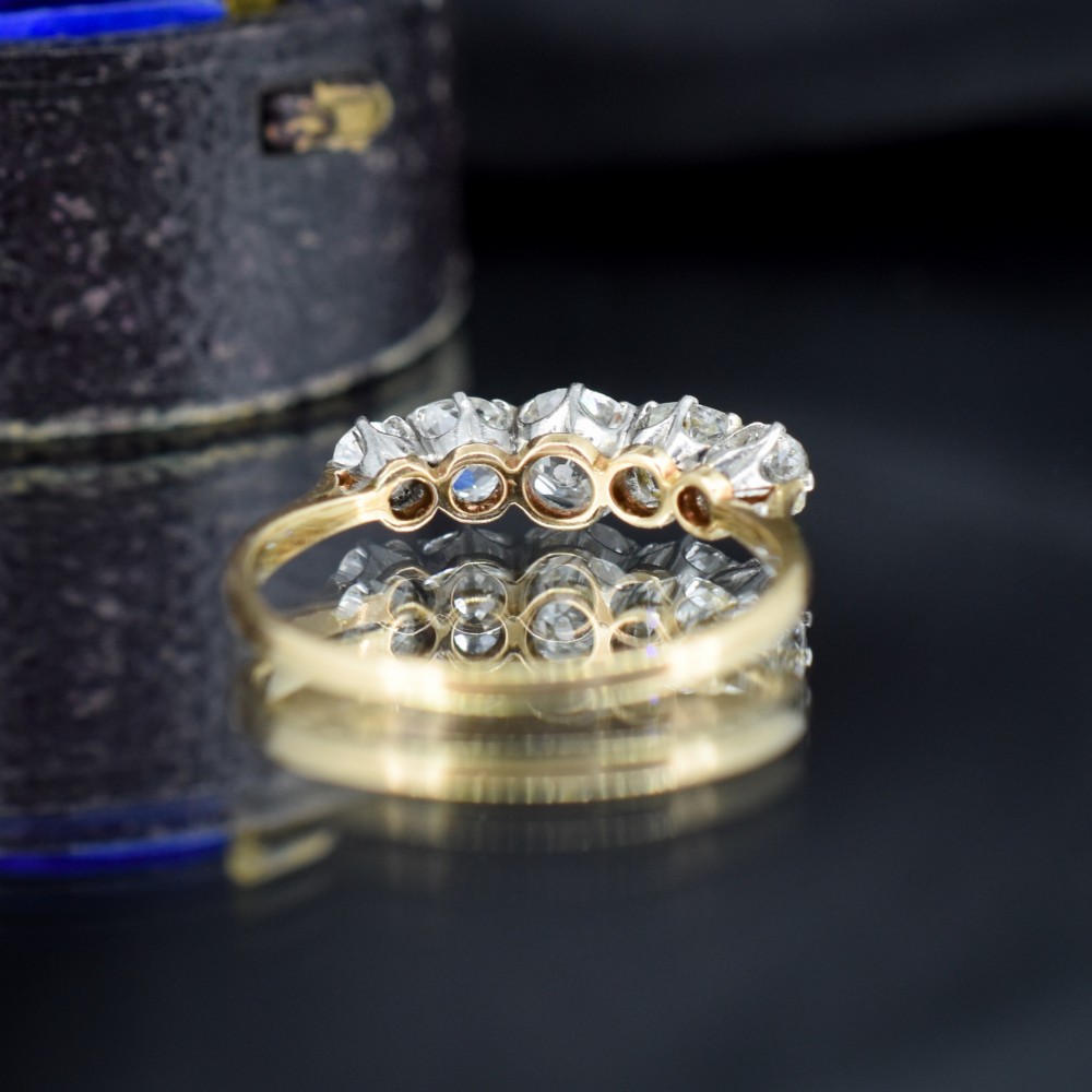 An antique five-stone ring featuring five graduated old cut diamonds set in a row mounted on a gold band. View VI