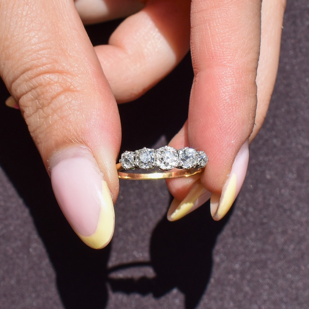 An antique five-stone ring featuring five graduated old cut diamonds set in a row mounted on a gold band. View VIII