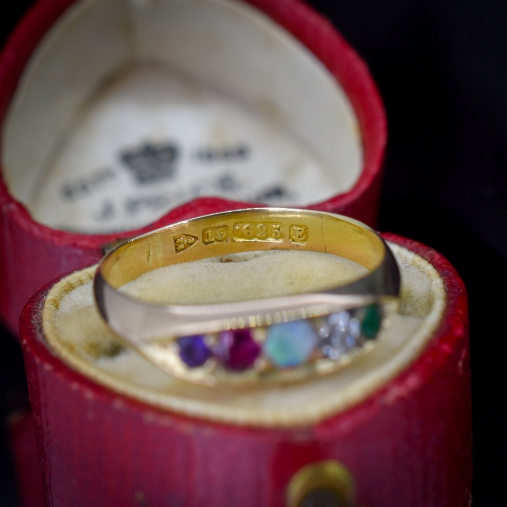 An antique Victorian 15ct yellow gold five-stone ring flush-set with five varied round gemstones across a polished band. View III