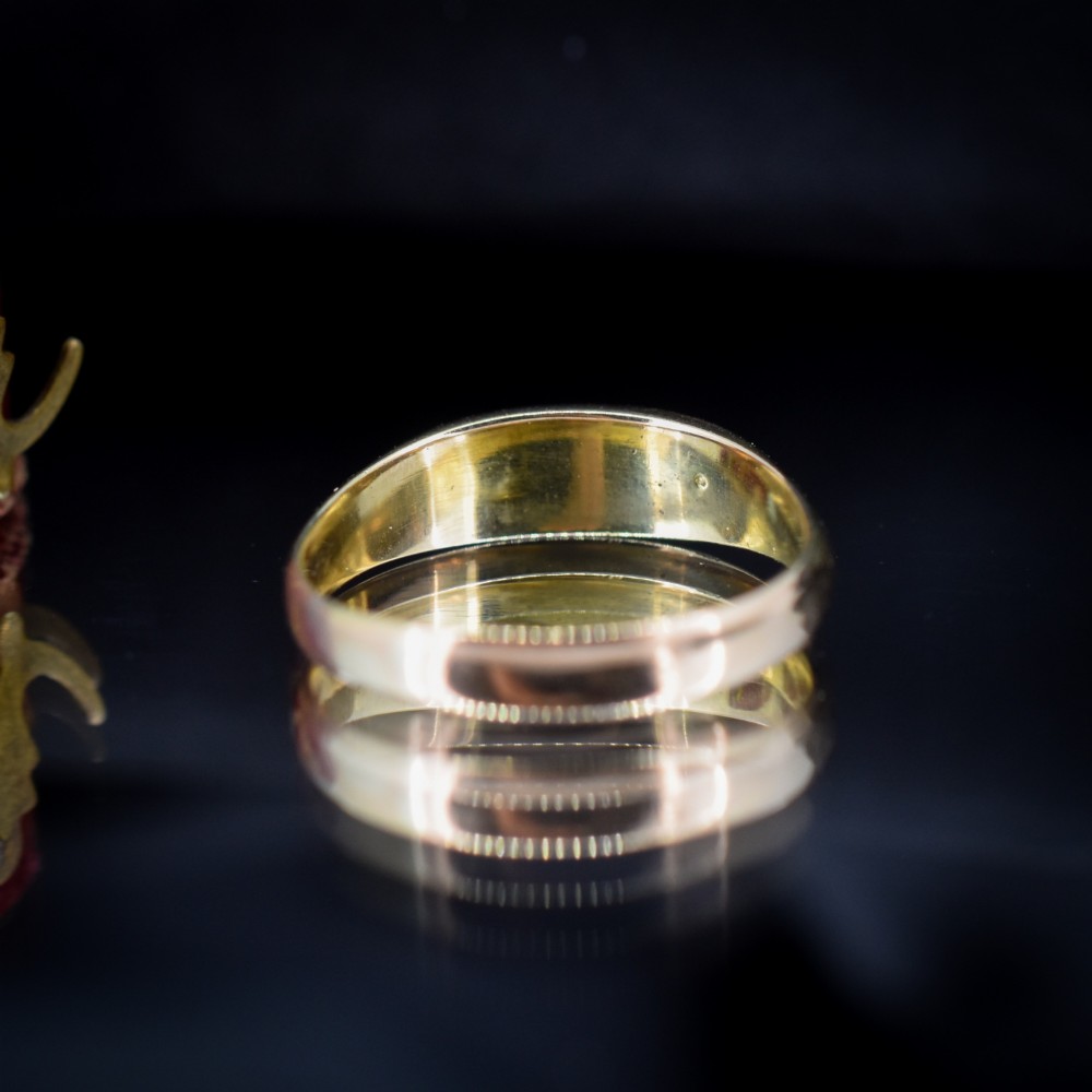 An antique Victorian 15ct yellow gold five-stone ring flush-set with five varied round gemstones across a polished band. View V