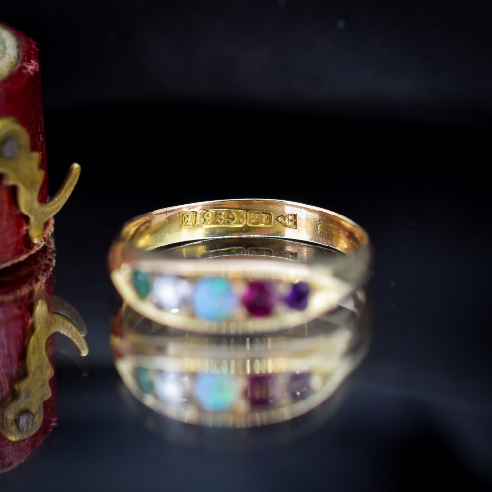 An antique Victorian 15ct yellow gold five-stone ring flush-set with five varied round gemstones across a polished band. View VII