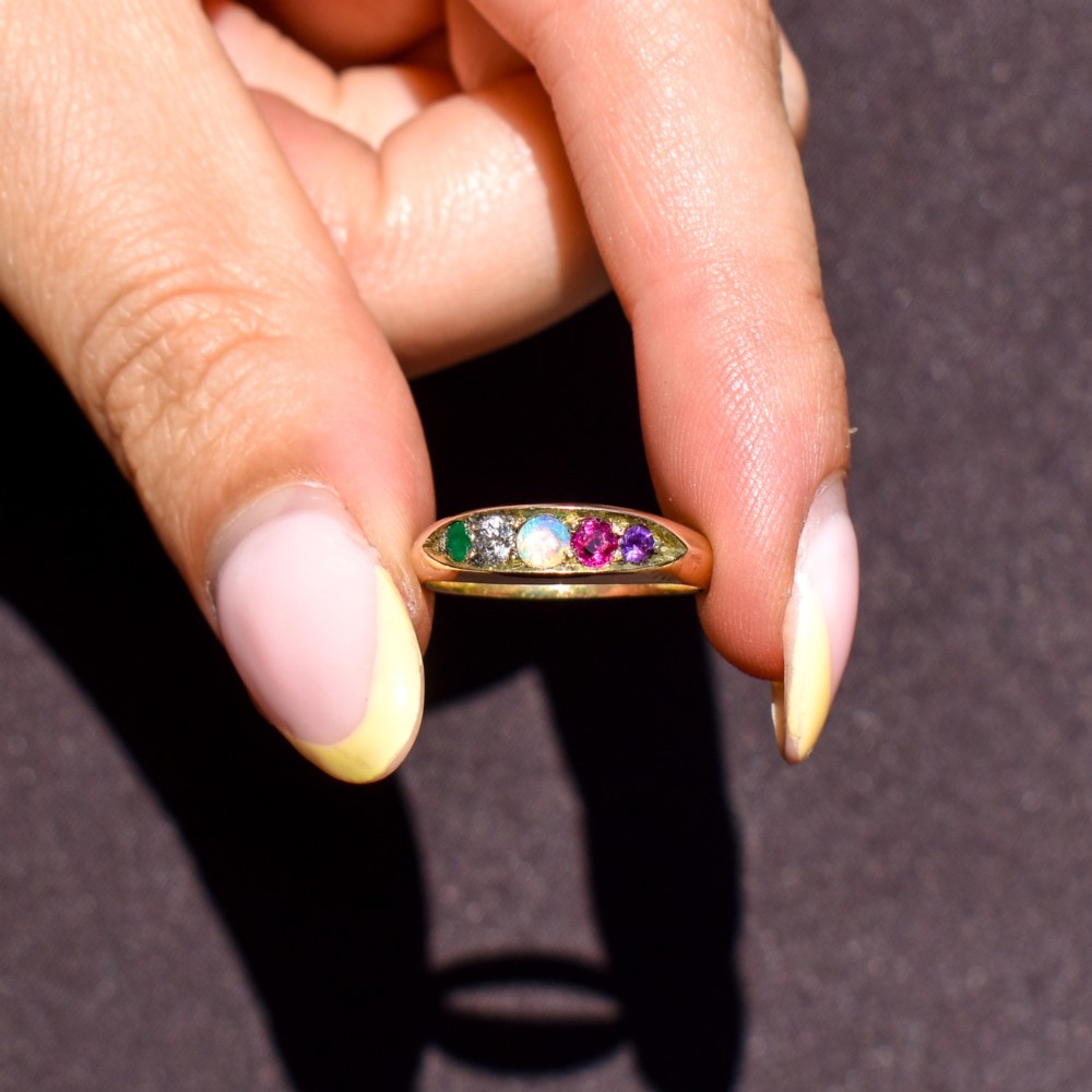 An antique Victorian 15ct yellow gold five-stone ring flush-set with five varied round gemstones across a polished band. View VIII