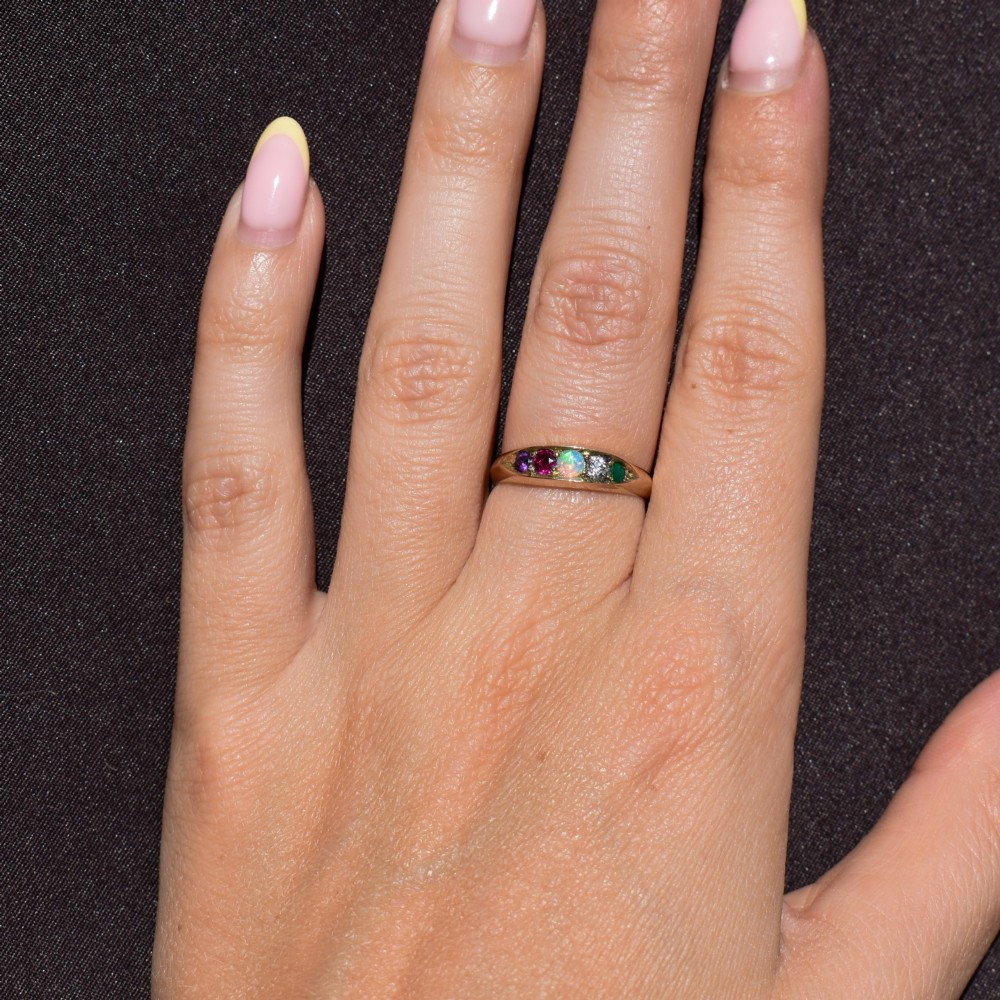 An antique Victorian 15ct yellow gold five-stone ring flush-set with five varied round gemstones across a polished band. View XI
