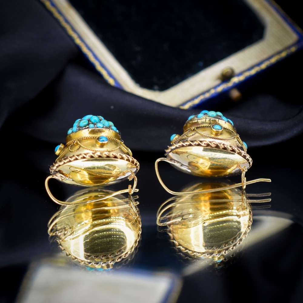 A pair of circular Victorian 9ct gold earrings featuring raised central domes set with pave turquoise cabochons and framed by decorative wirework. View V