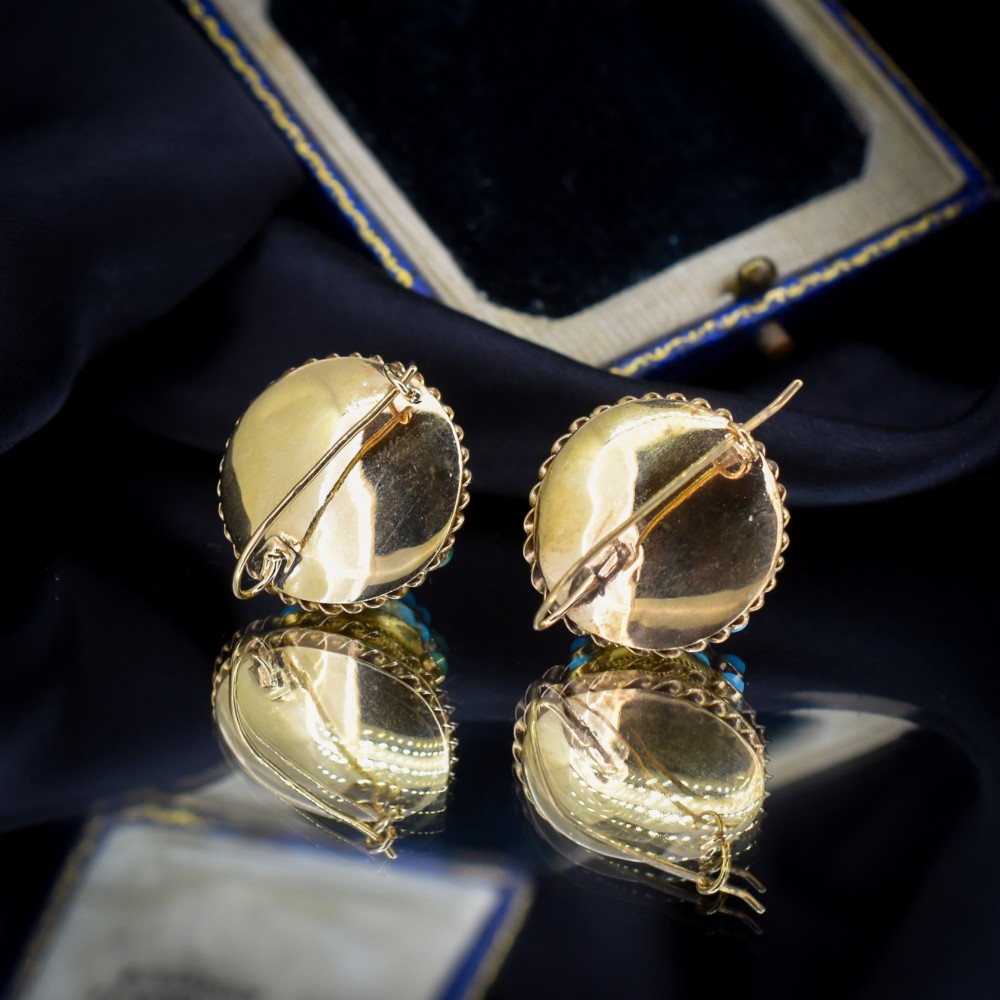 A pair of circular Victorian 9ct gold earrings featuring raised central domes set with pave turquoise cabochons and framed by decorative wirework. View VI