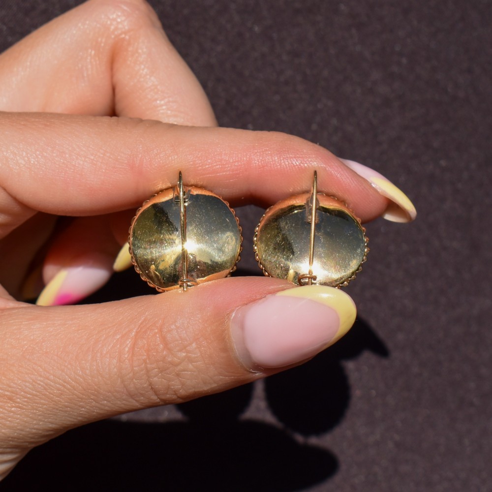 A pair of circular Victorian 9ct gold earrings featuring raised central domes set with pave turquoise cabochons and framed by decorative wirework. View X