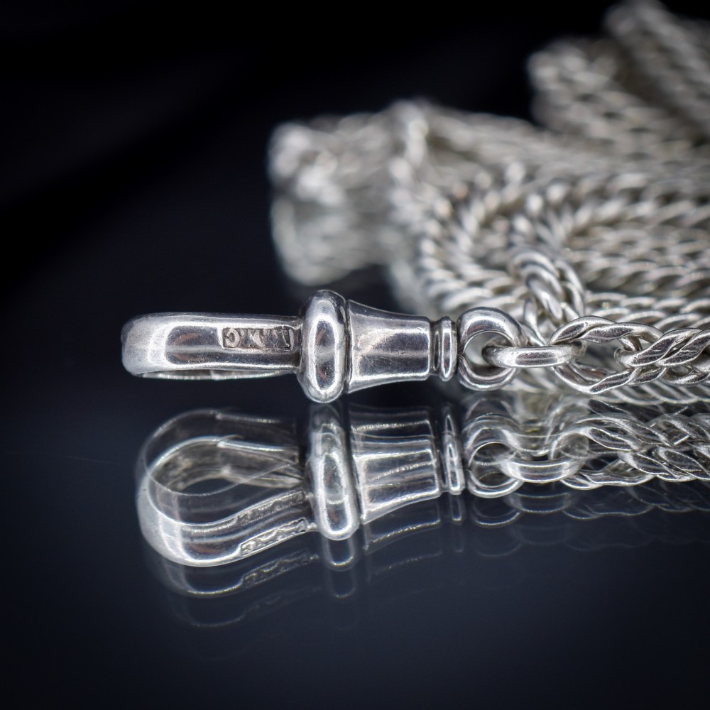 A long sterling silver flat curb link guard chain draped in multiple tiers with a dog clip clasp at the bottom. View VI