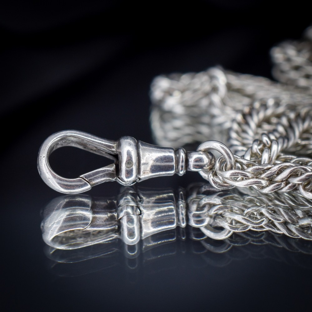 A long sterling silver flat curb link guard chain draped in multiple tiers with a dog clip clasp at the bottom. View VII