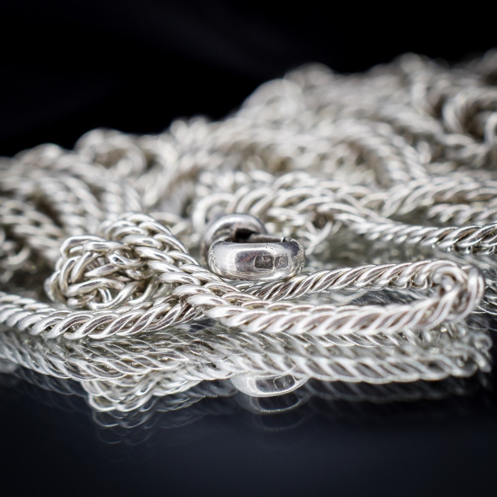 A long sterling silver flat curb link guard chain draped in multiple tiers with a dog clip clasp at the bottom. View VIII