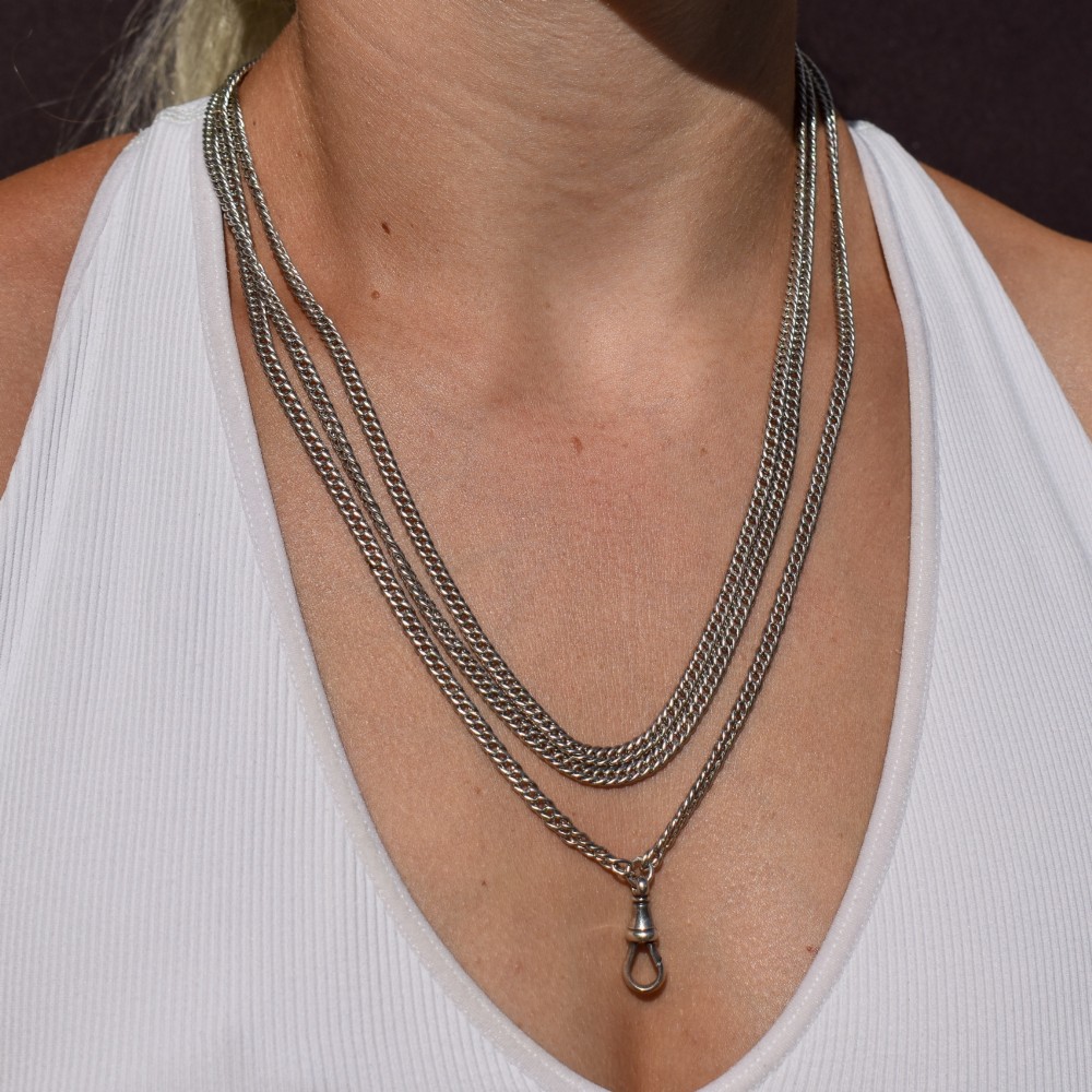 A long sterling silver flat curb link guard chain draped in multiple tiers with a dog clip clasp at the bottom. View XIII