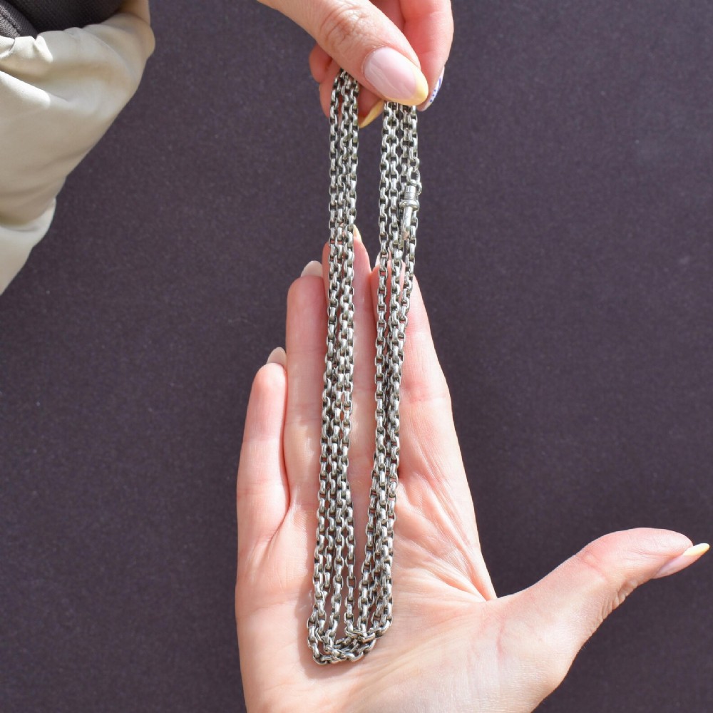 A long silver guard chain necklace constructed with interlocking round links and fitted with a dog clip swivel clasp.