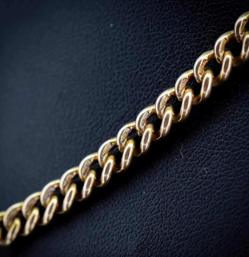 An antique 15ct yellow gold Albert chain necklace featuring curb links, a T-bar drop, a bolt ring, and a dog clip clasp. View X