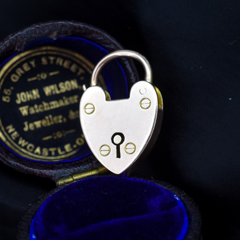 An antique 9ct gold heart-shaped padlock pendant with a smooth polished finish, central keyhole detail, and visible screw head accents. View II