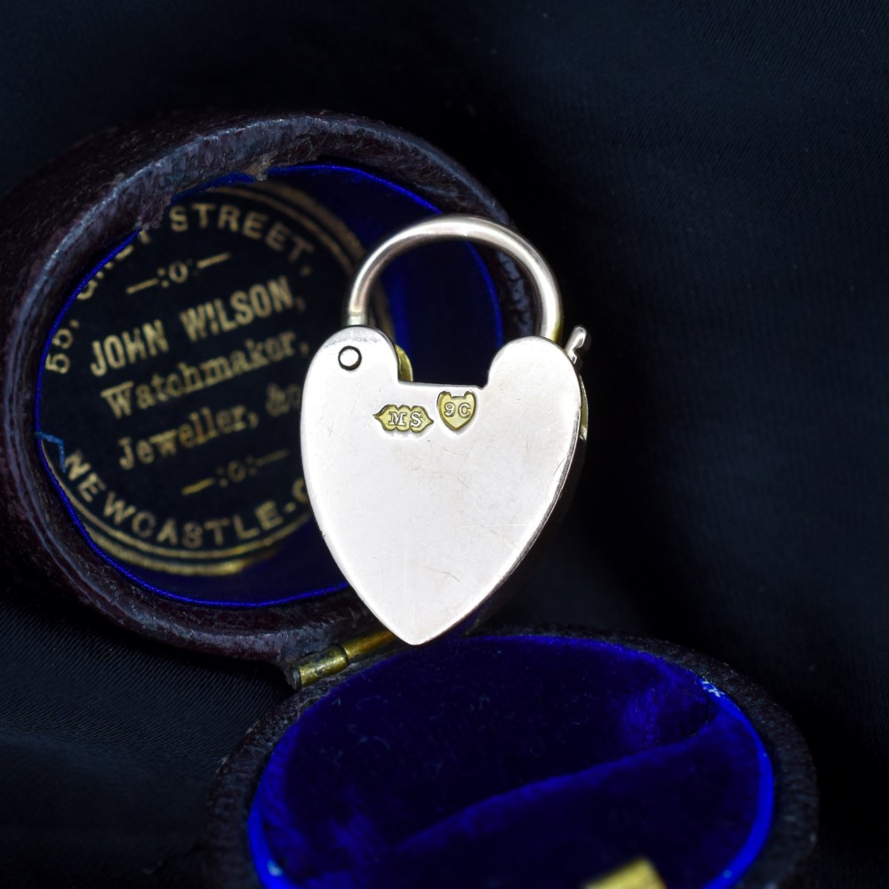An antique 9ct gold heart-shaped padlock pendant with a smooth polished finish, central keyhole detail, and visible screw head accents. View III