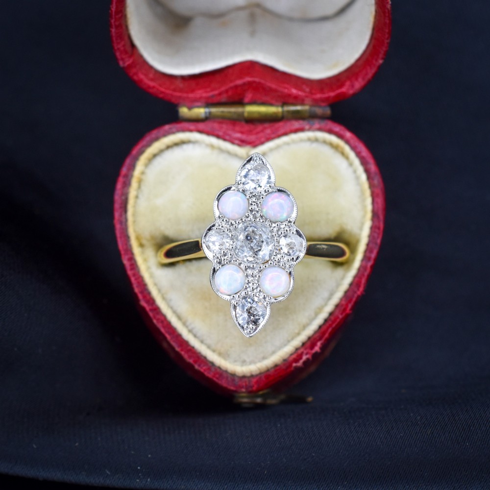 An Edwardian 18ct gold and platinum navette cluster ring featuring a central old cut diamond bordered by four cabochon opals and additional diamond accents. View III