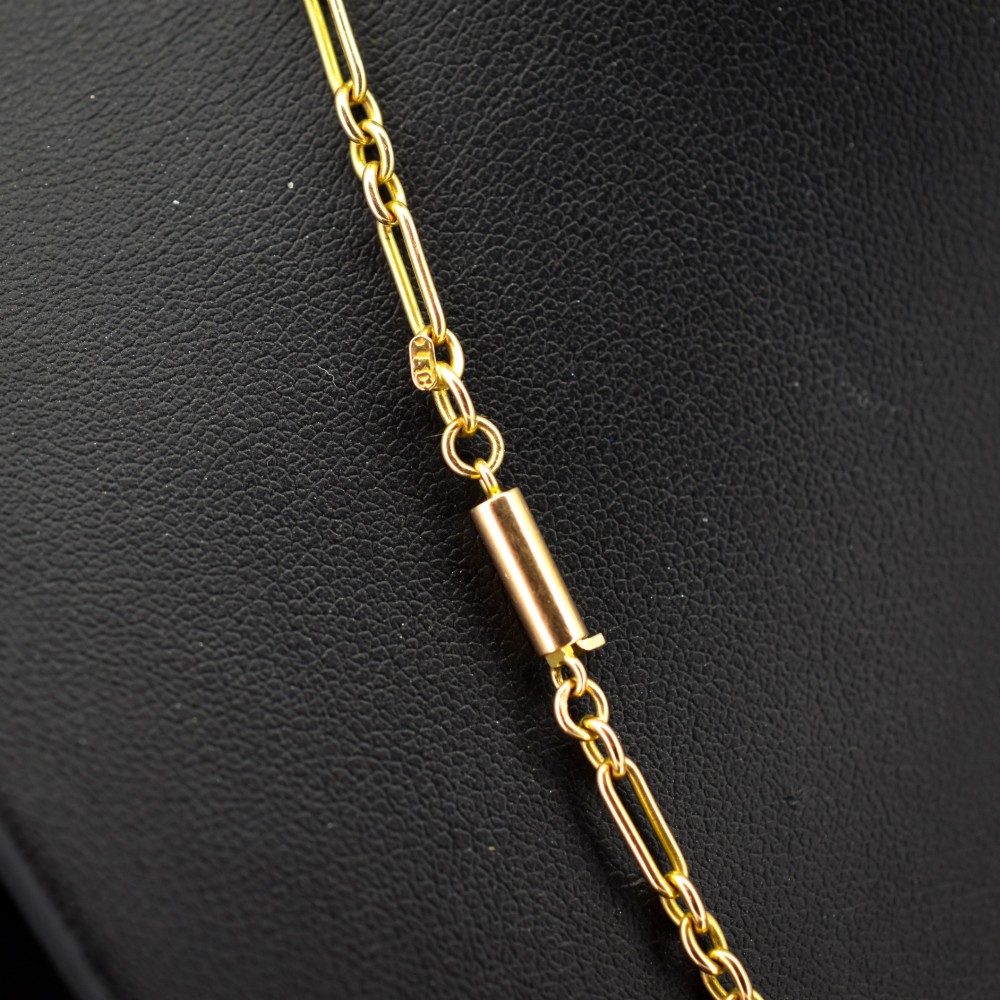 An antique 15ct yellow gold chain featuring alternating long trombone links and short oval links with a barrel clasp. View IV