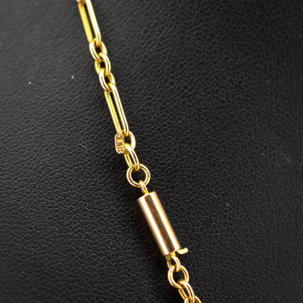 An antique 15ct yellow gold chain featuring alternating long trombone links and short oval links with a barrel clasp. View V