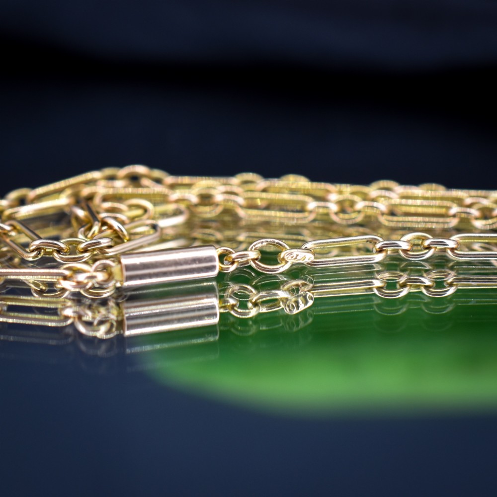 An antique 15ct yellow gold chain featuring alternating long trombone links and short oval links with a barrel clasp. View VII