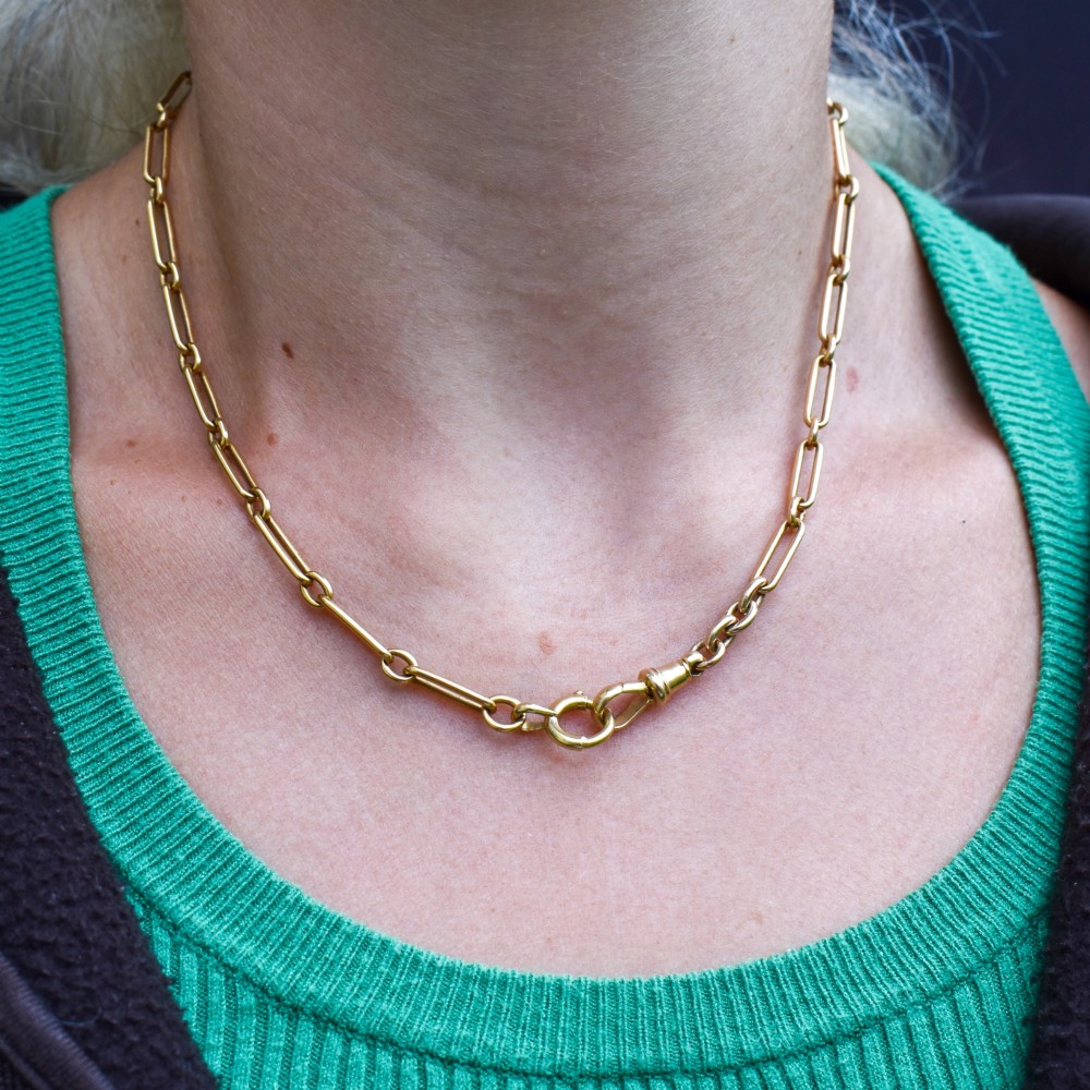 An antique 15ct yellow gold chain featuring alternating long trombone links and short oval links with a barrel clasp. View XII