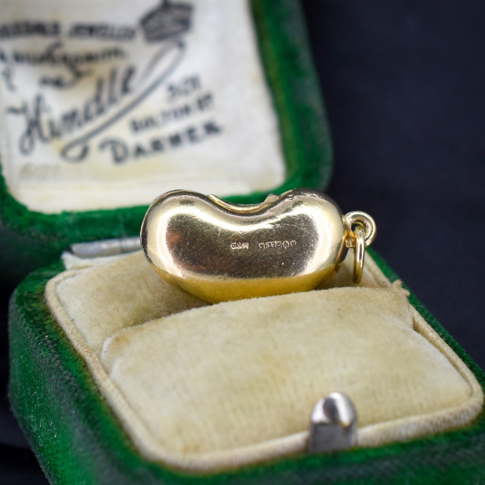 A smooth, polished 9ct yellow gold bean-shaped charm with an attached suspension jump ring. View III