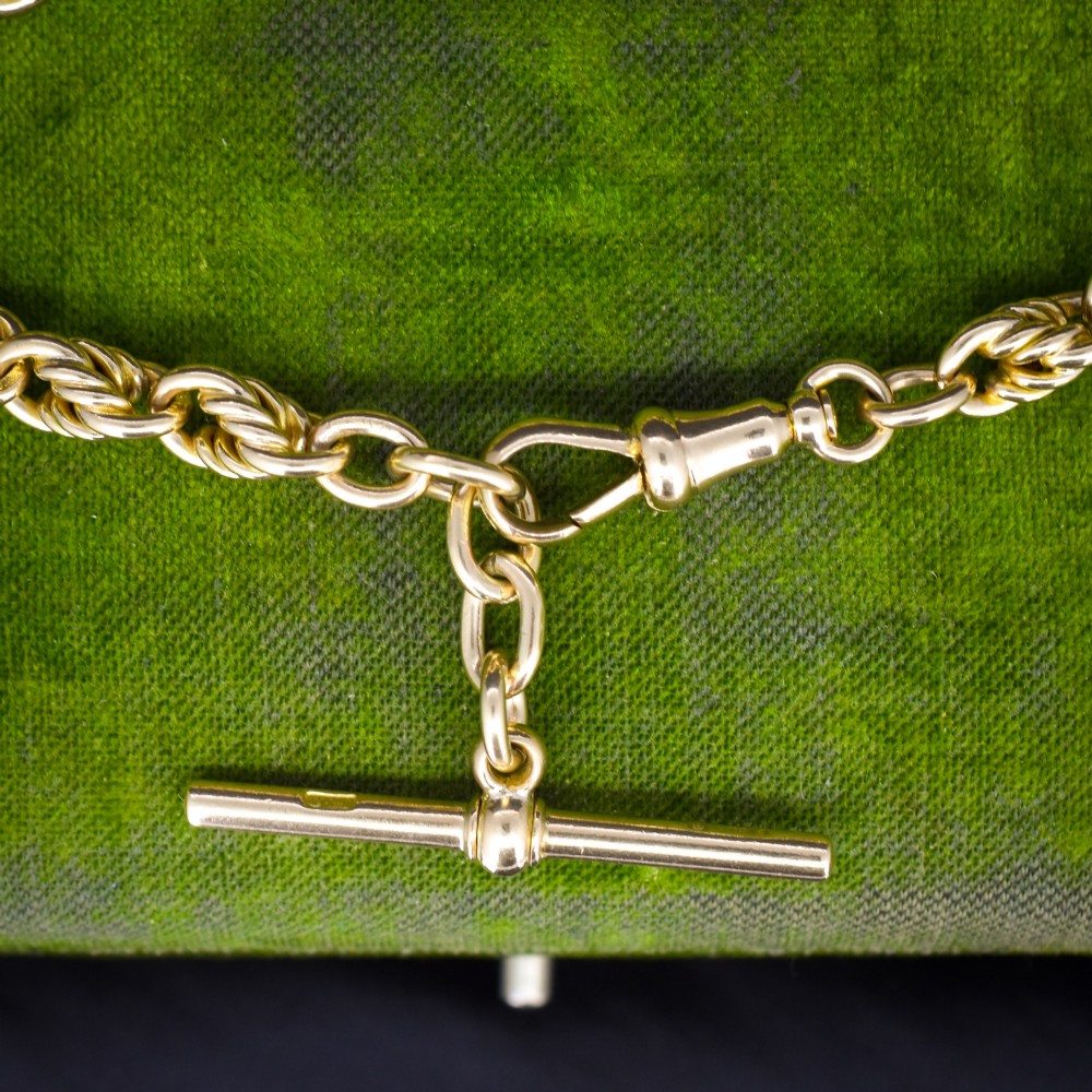 An antique 9ct yellow gold love knot chain bracelet featuring a swivel clasp and suspended T-bar detail. View II