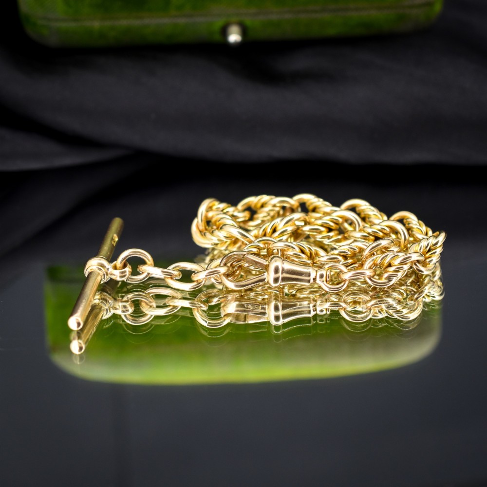 An antique 9ct yellow gold love knot chain bracelet featuring a swivel clasp and suspended T-bar detail. View III