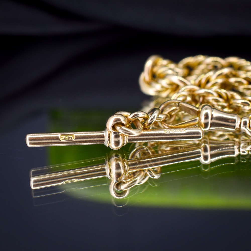 An antique 9ct yellow gold love knot chain bracelet featuring a swivel clasp and suspended T-bar detail. View IV