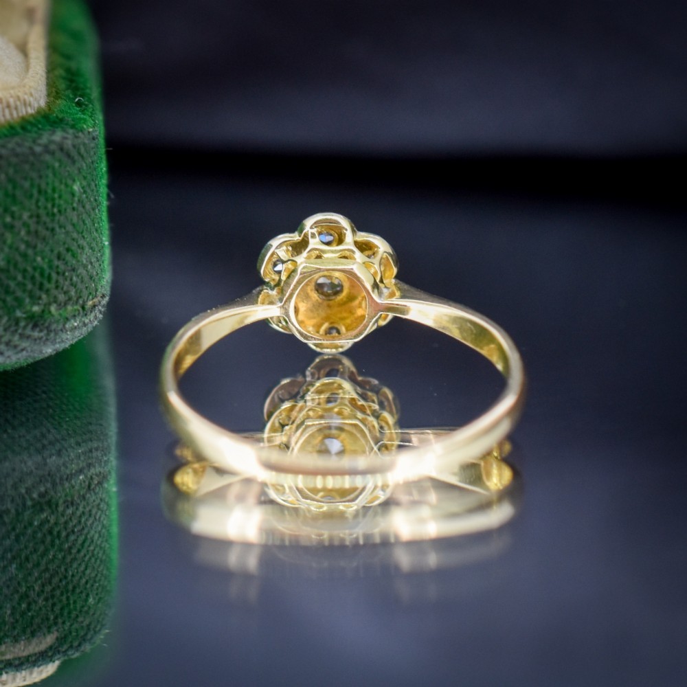 An antique 18ct yellow gold ring featuring a floral diamond cluster head set in platinum. View IV