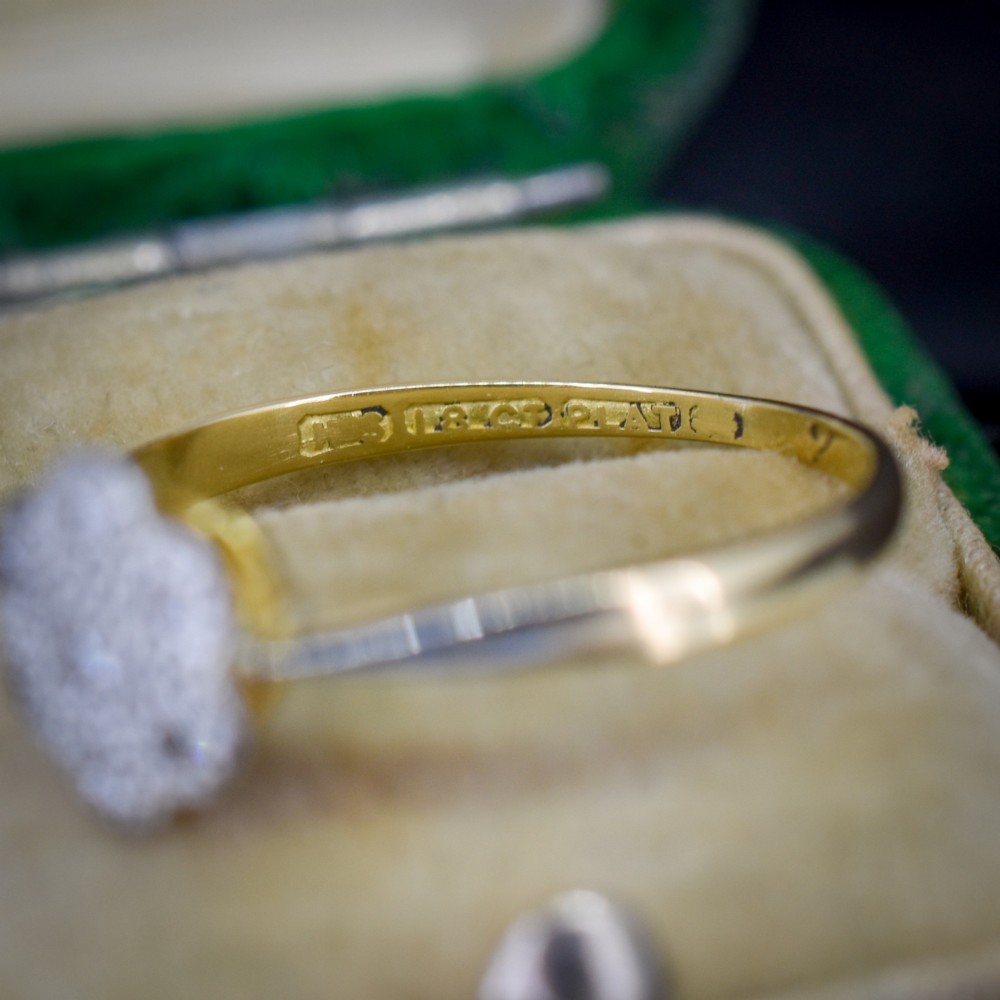An antique 18ct yellow gold ring featuring a floral diamond cluster head set in platinum. View VI