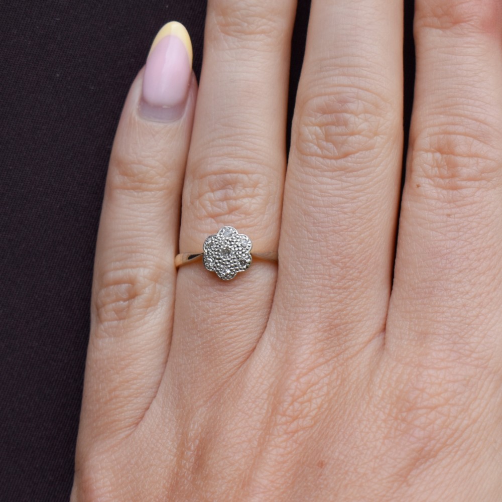 An antique 18ct yellow gold ring featuring a floral diamond cluster head set in platinum. View X