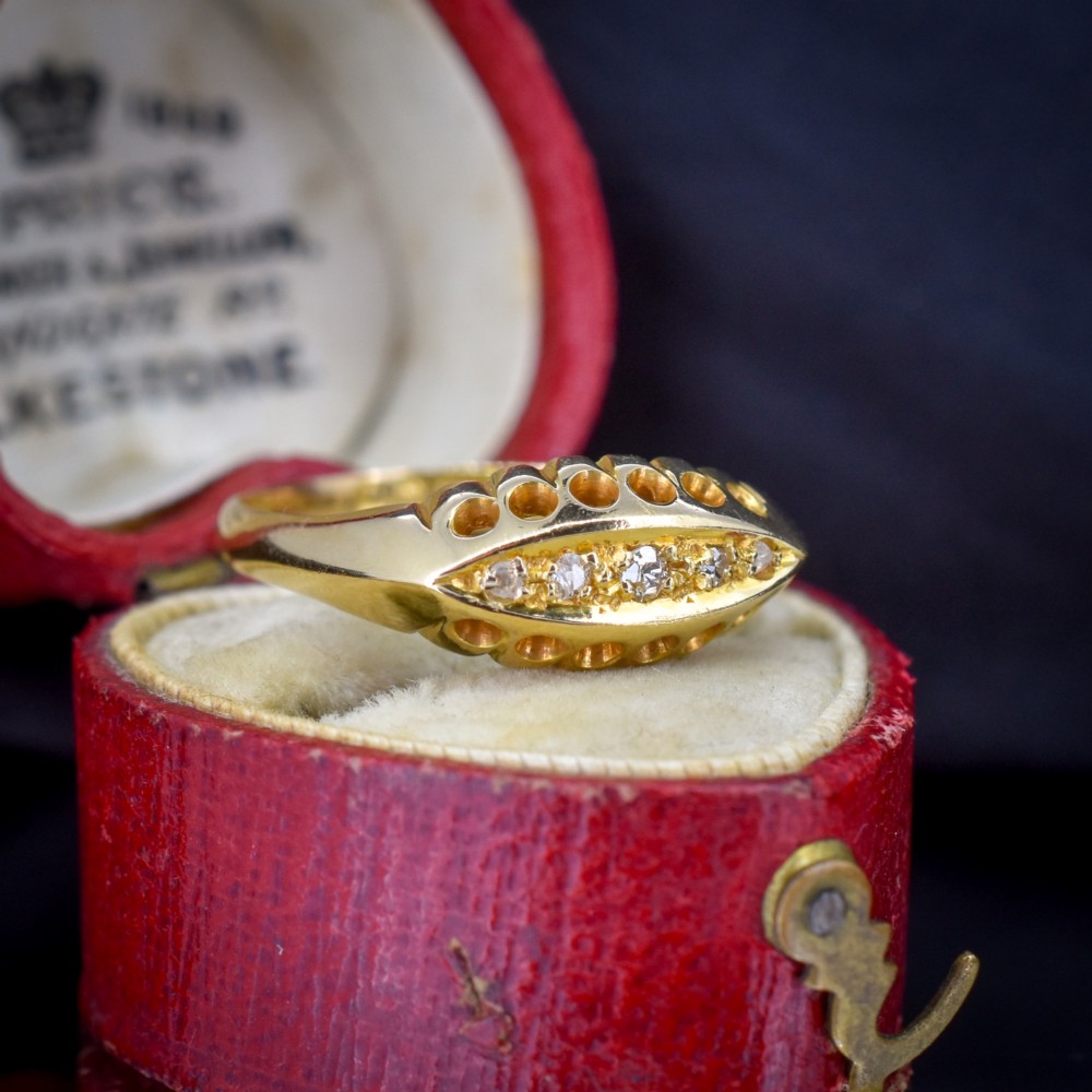 An 18ct yellow gold boat ring set with five graduated diamonds within a carved pierced gallery. View II