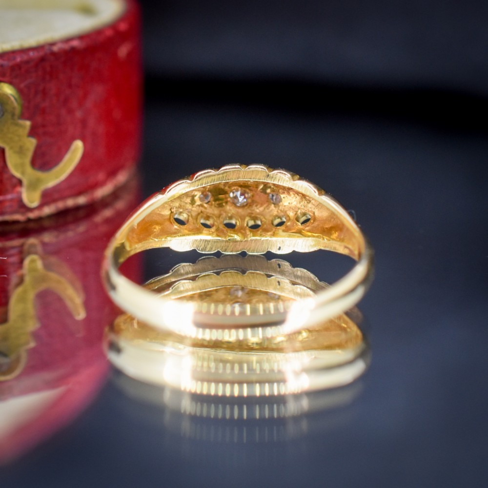 An 18ct yellow gold boat ring set with five graduated diamonds within a carved pierced gallery. View VII