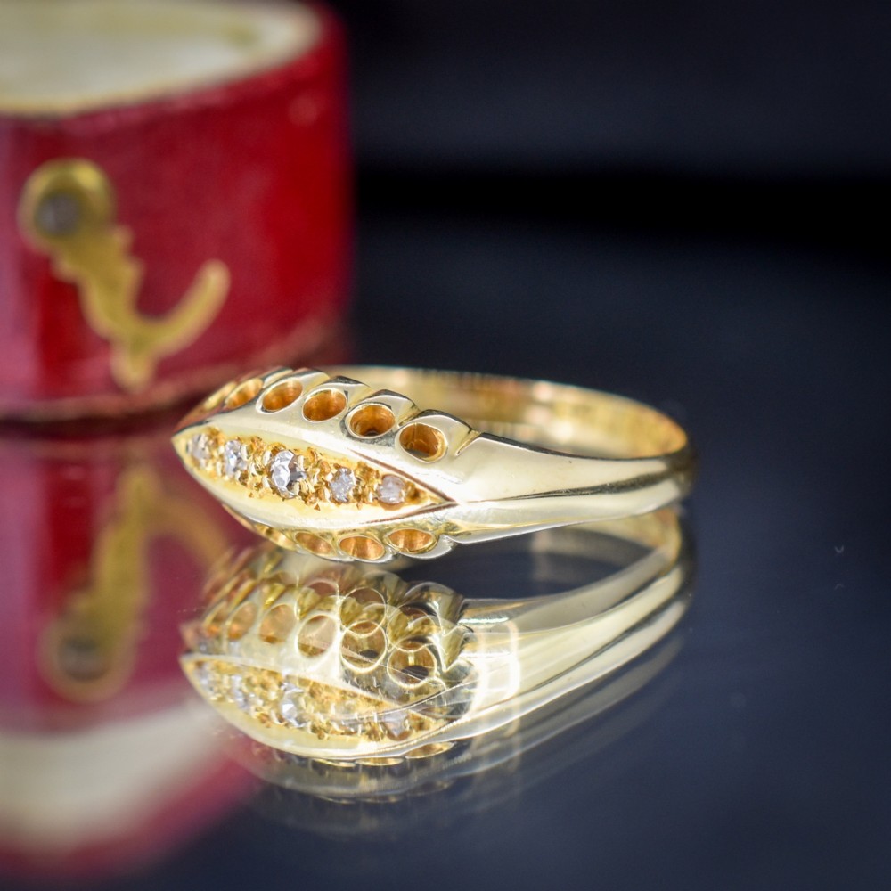 An 18ct yellow gold boat ring set with five graduated diamonds within a carved pierced gallery. View VIII