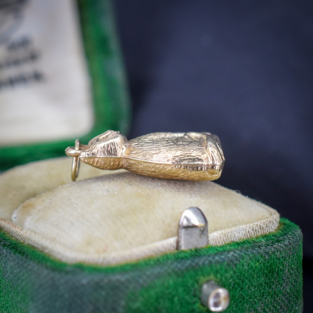 A small 9ct yellow gold charm shaped as a seated cat with engraved fur texture and a loop at the top for suspension. View IV