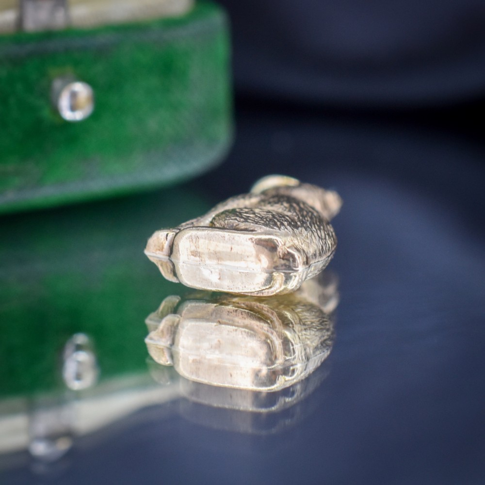 A small 9ct yellow gold charm shaped as a seated cat with engraved fur texture and a loop at the top for suspension. View VI