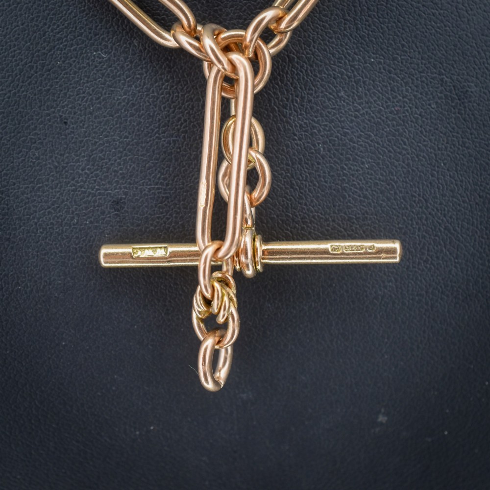 An antique 9ct yellow gold necklace featuring elongated trombone links, twisted love knots, and a central suspended T-bar. View II