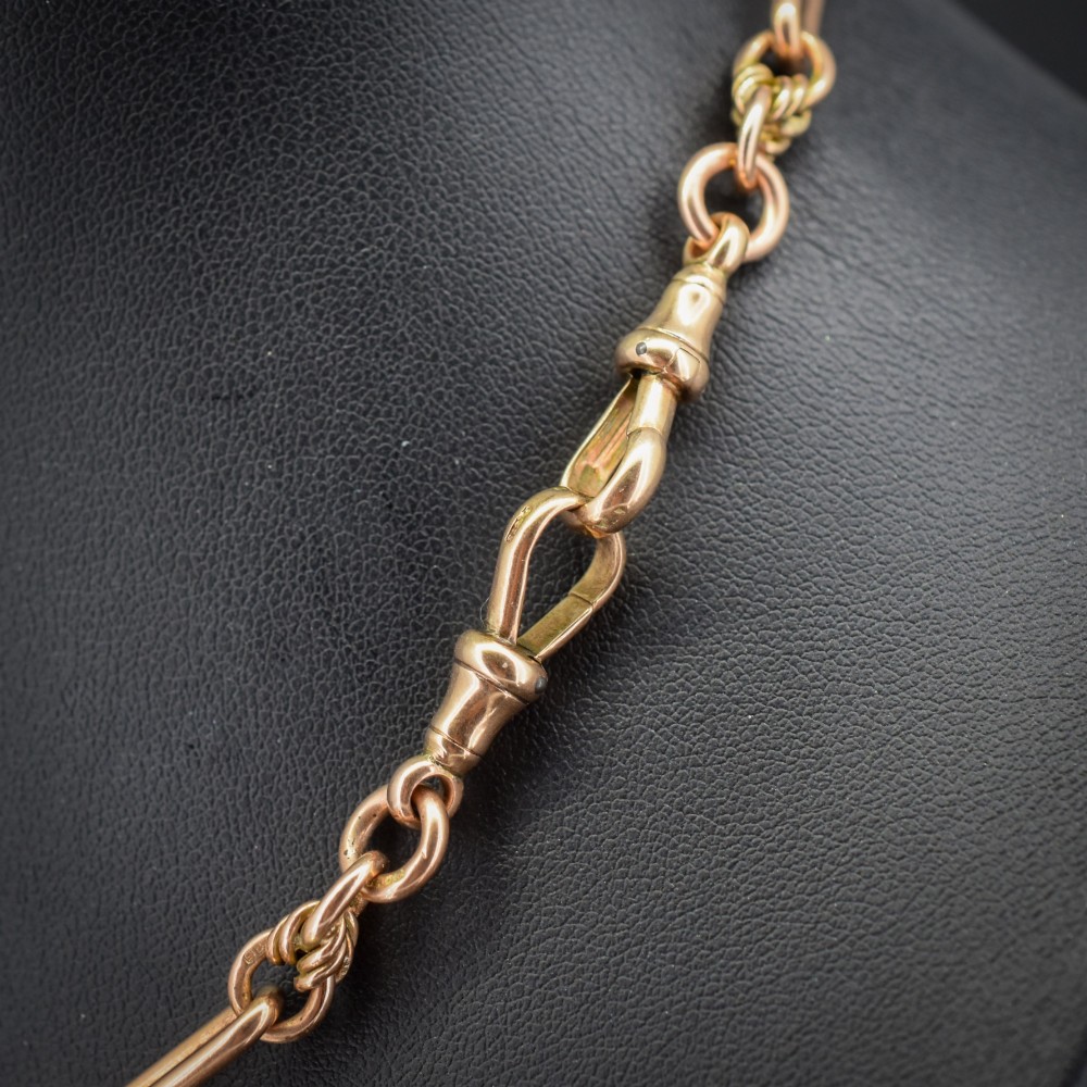 An antique 9ct yellow gold necklace featuring elongated trombone links, twisted love knots, and a central suspended T-bar. View V